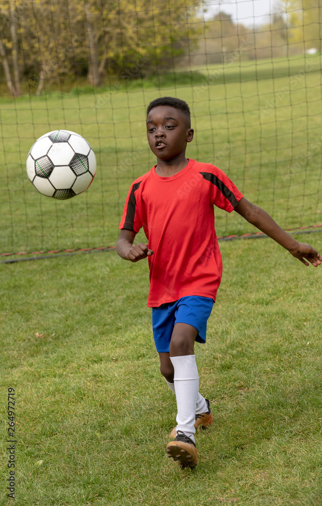 Hampshire, England, UK. April 2019. A young football player defending the goal during a traning session in a public park.