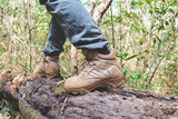 close-up hiking boots. male tourist steps on a login forest