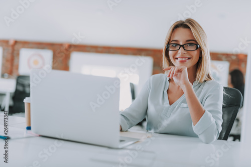 Confident young specialist smiling and working in the office
