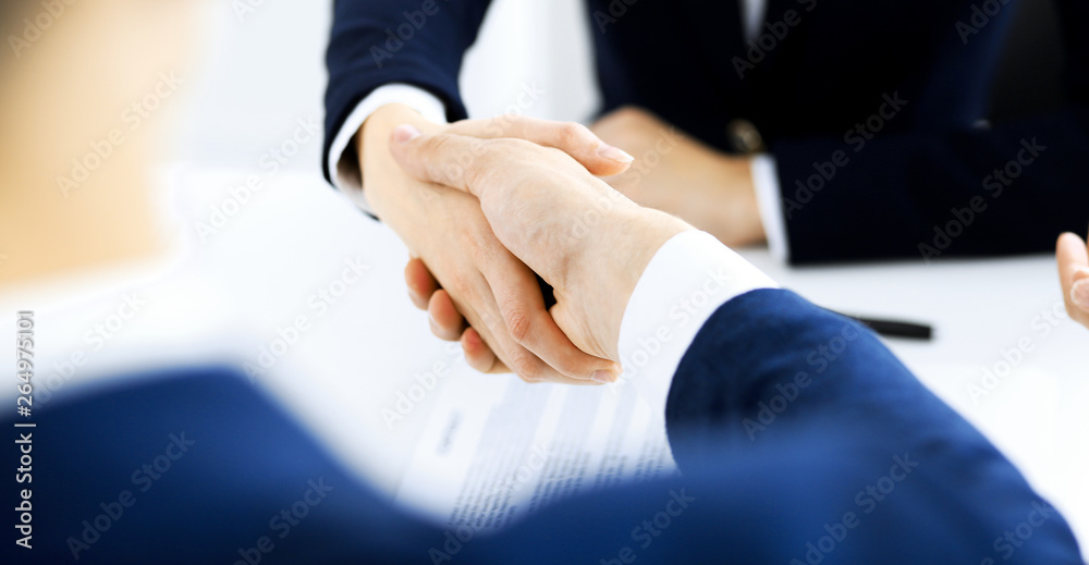 Business people shaking hands finishing up a meeting , close-up. Success at negotiation and handshake concepts. Group of lawyers at work