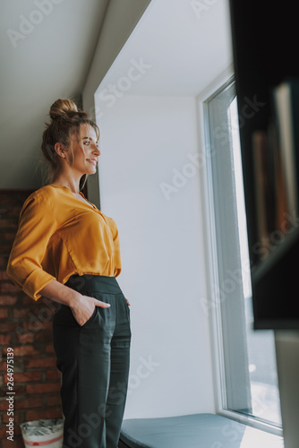 Woman standing in front of the window and smiling Free Download Woman standing in front of the window and smiling - GFXLoad