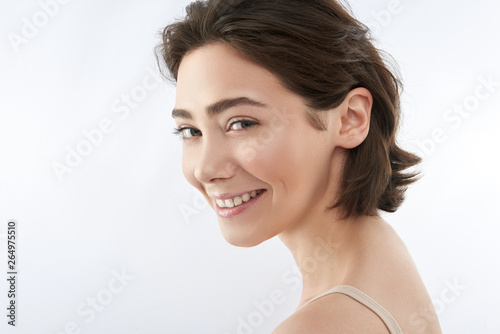 Side on of happy brunette female on white
