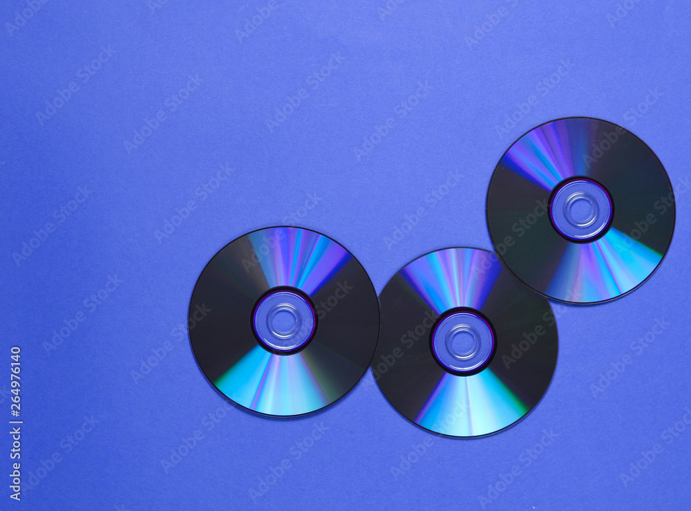 Three CD's on blue background. Top view Three CD's on blue background. Top view