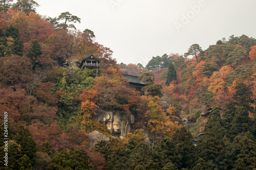 Wooden Temple on mountain during forest  leaves change to orange in Autumn season of Japan