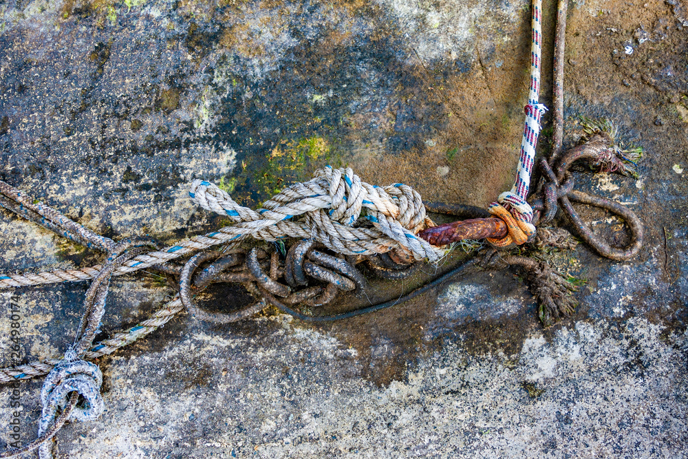 Ropes and rusty steel bar at an old harbour.