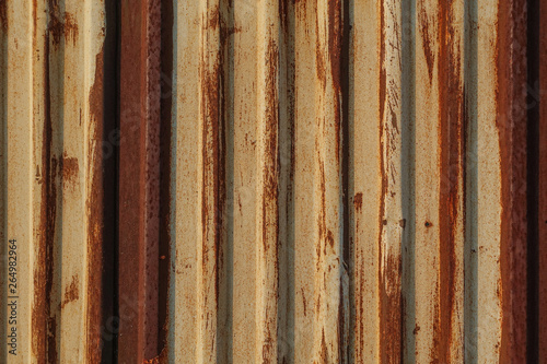 Rust on the gland. Corrugated iron sheet with peeling yellow paint. Texture and background. Yellow red