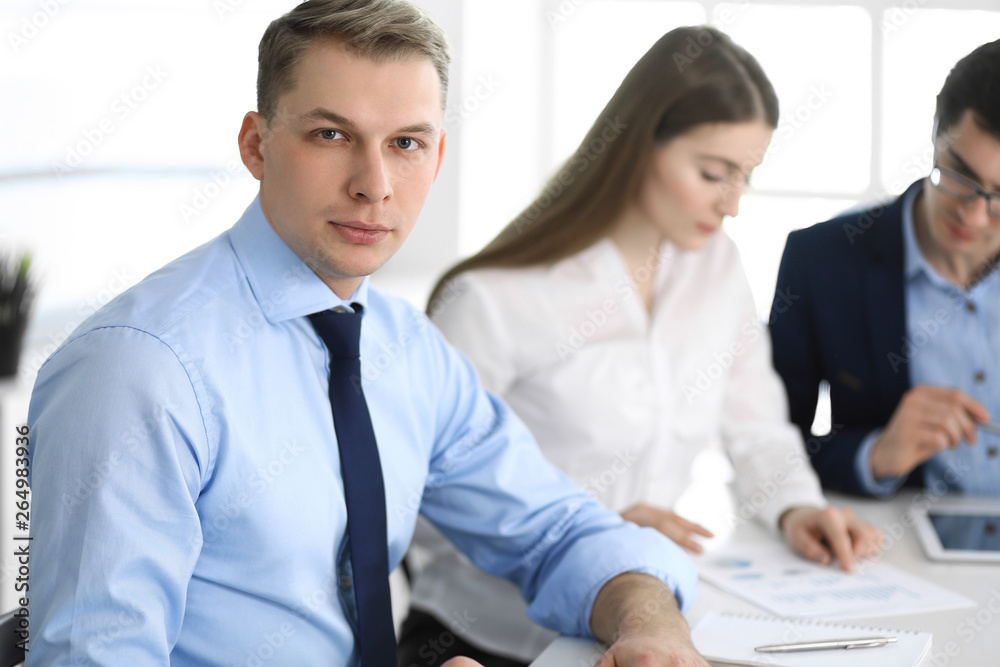 Group of business people discussing questions at meeting in modern office. Headshot of businessman at negotiation. Teamwork, partnership and business concept Group of business people discussing questions at meeting in modern office. Headshot of businessman at negotiation. Teamwork, partnership and business concept