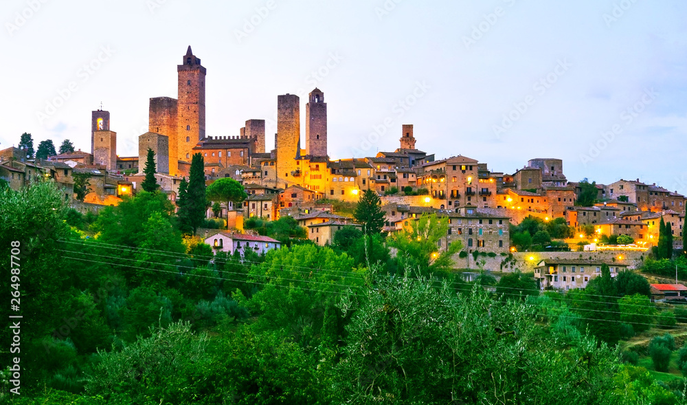 View of the historic cityscape of San Gimignano facing the countryside in Tuscany, Italy at  dusk.