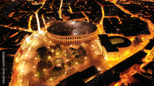 Aerial drone night shot from iconic illuminated Arena theatre and City Hall in Bra square of beautiful city of Verona, Lombardy, Italy photo