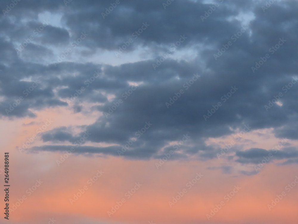 Pink and blue grey romantic clouds lit by the evening sun. Background texture