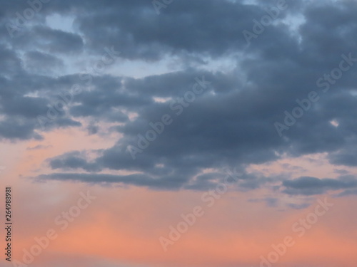 Pink and blue grey romantic clouds lit by the evening sun. Background texture