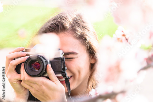 Young woman looks into camera lens and laughs