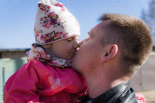 Father kisses his little daughter on the street