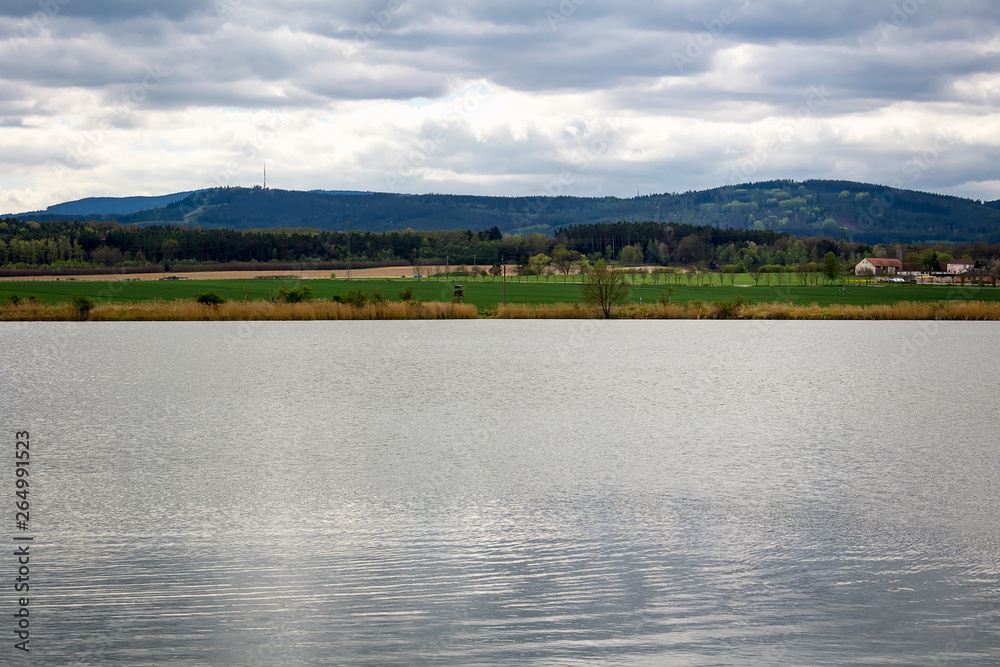 Pond with hill Klet and cloud sky, Czech landscape
