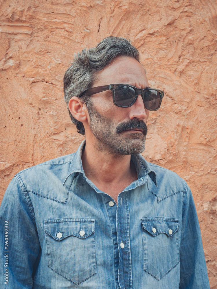 attractive man with beard posing in the field in an old house attractive man with beard posing in the field in an old house