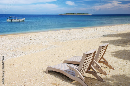 Sun chairs on white sandy beach photo