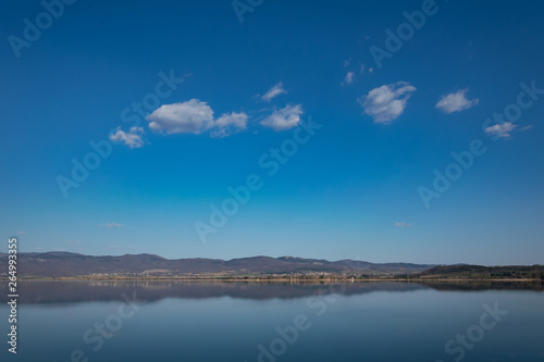 View of the lake and mountains on a sunny spring day.