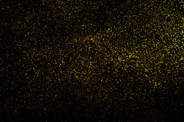 Golden glitter scattered on the black card background, top view, selective focus