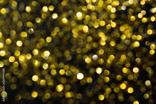 Abstract blurred glitter bokeh background in gold  on black