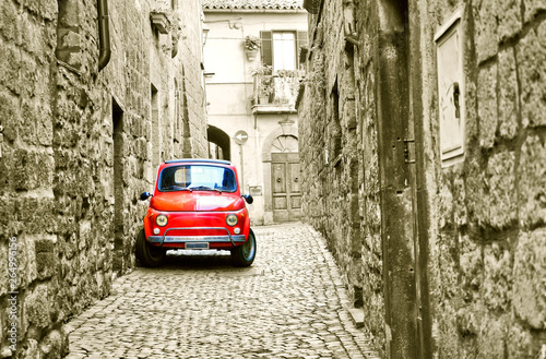 View of a small red car in the historic cityscape in Orvieto  Italy. 