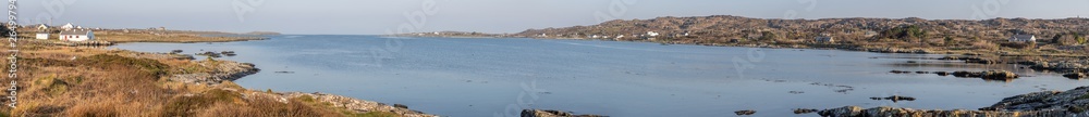 Panorama of Beach houses, Vegetation and rocks around Clifden bay