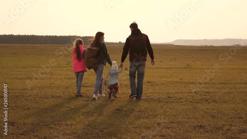 dad, mom, daughters and pets, tourists. teamwork of a close-knit family. family travels with the dog across the plains and mountains. The concept of a sports family holiday in nature.