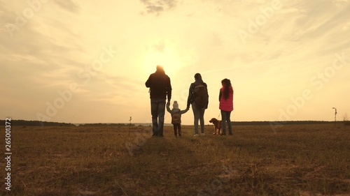Dad  Mom  small child and daughters and pets tourists. teamwork of a close-knit family. family travels with the dog on the plain. The concept of a sports family holiday in nature.
