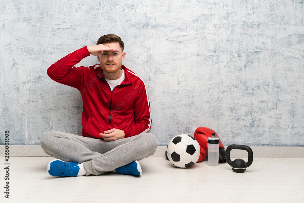 Redhead sport man looking far away with hand to look something Redhead sport man looking far away with hand to look something