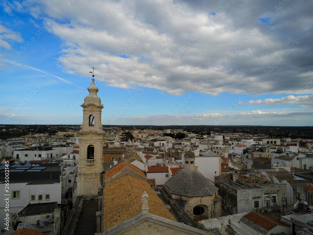 Aerial Shot of the Belltower of the Church of the Nativity in the City of Noci, Near Bari, in the South of Italy, on Partially Cloudy Sky Background