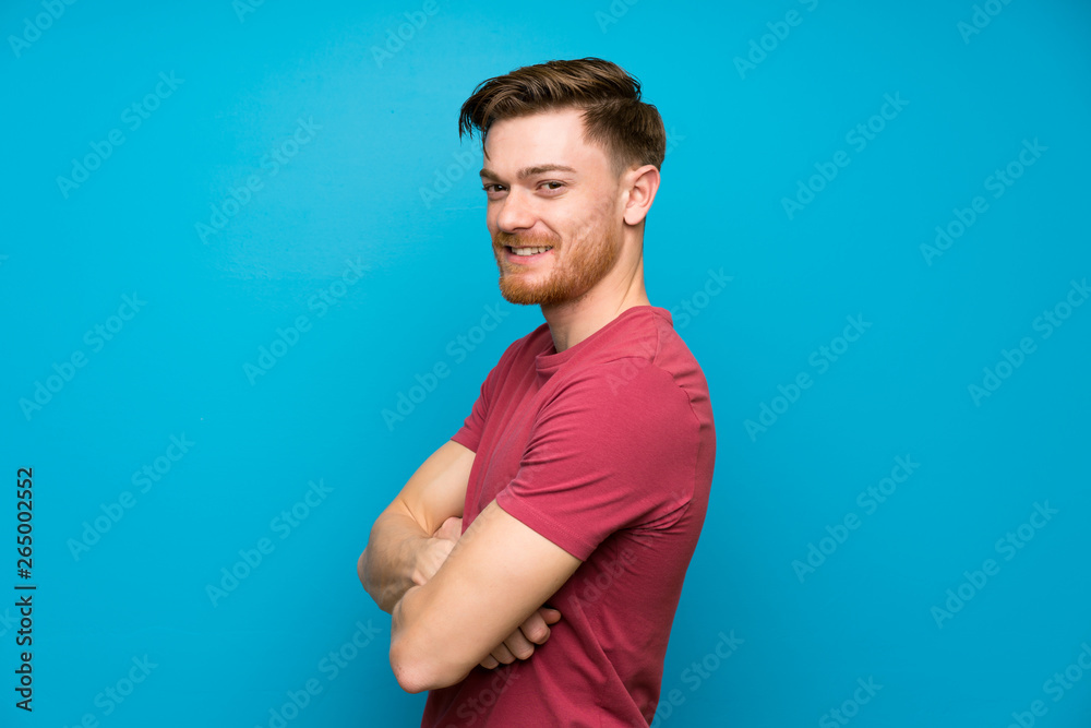 Redhead man on isolated blue wall laughing Redhead man on isolated blue wall laughing
