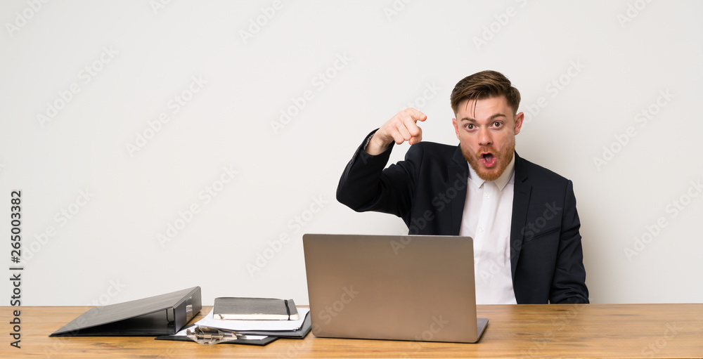 Businessman in a office surprised and pointing front Businessman in a office surprised and pointing front