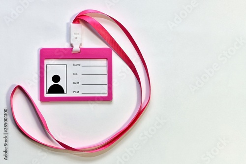 Pink new blank unfilled badge with satin ribbon on the left. On a light background to the left.