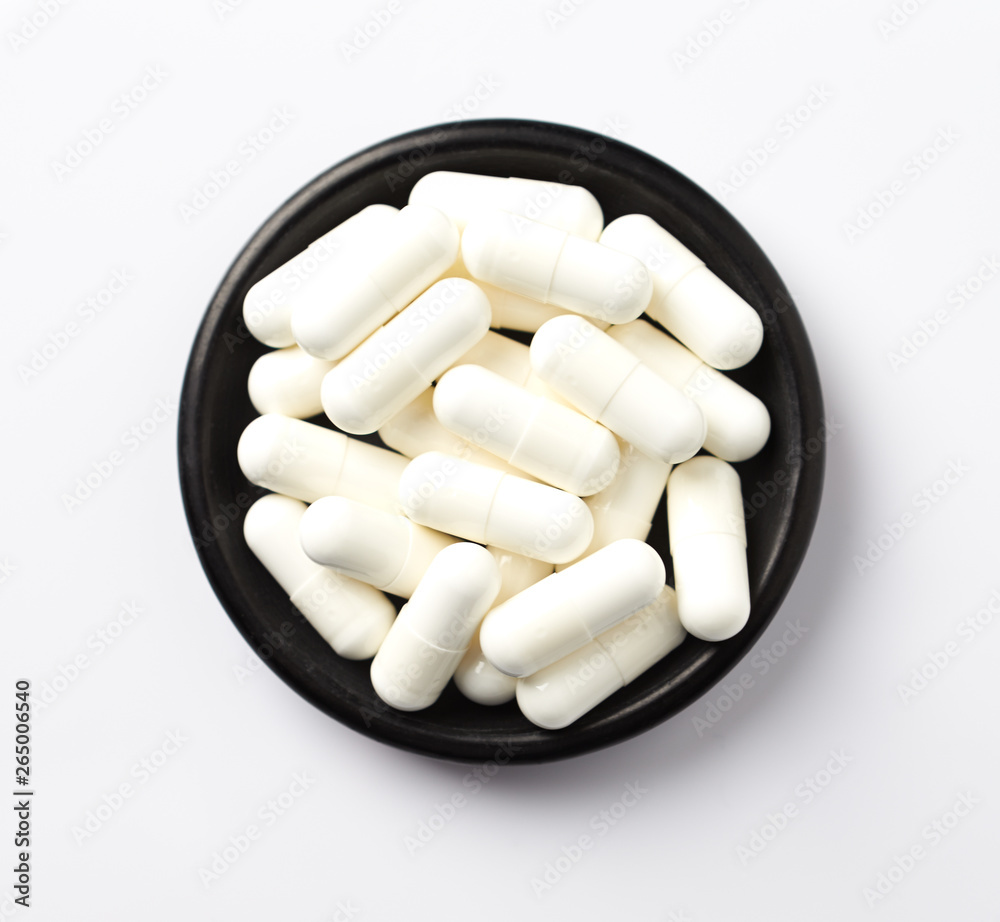 Creatine capsules. Bodybuilding food supplement on white background. Top view. Copy space Creatine capsules. Bodybuilding food supplement on white background. Top view. Copy space