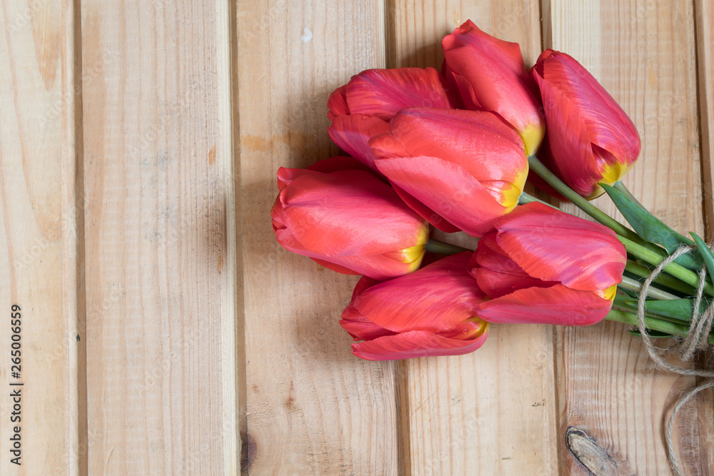 a bouquet of tulips lay on a wooden table