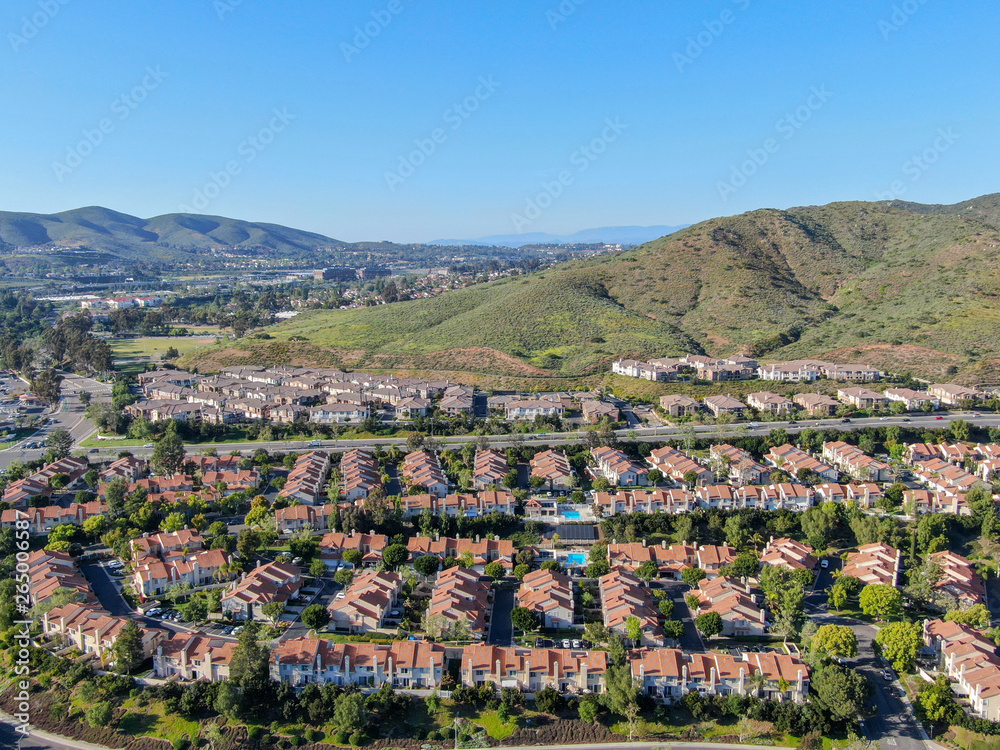 Aerial view suburban neighborhood with identical villas next to each other in the valley. San Diego, California, USA. Aerial view of residential modern subdivision luxury house with swimming pool.