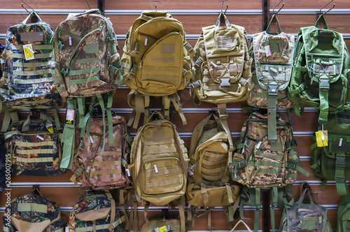 Camouflage backpacks on the shelf in the store. Sale of camouflage backpacks