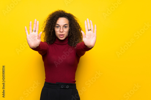Dominican woman with turtleneck sweater making stop gesture for disappointed with an opinion