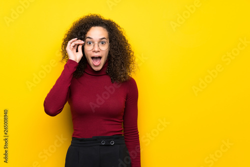 Dominican woman with turtleneck sweater with glasses and surprised