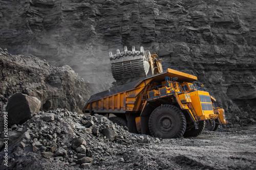 loader bucket on loading coal into a mining truck photo