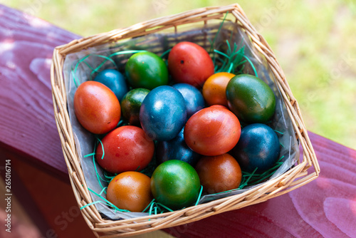 Easter eggs in a knitted basket on a wooden background