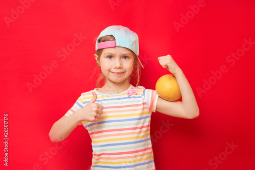 Attractive little girl shows the biceps on a red background. Feel so powerful. Girls rules concept. Upbringing advices for girls. Strong and powerful © irena_geo