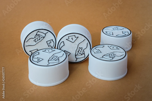 Фотография Plastic child resistant bottle caps on a brown background