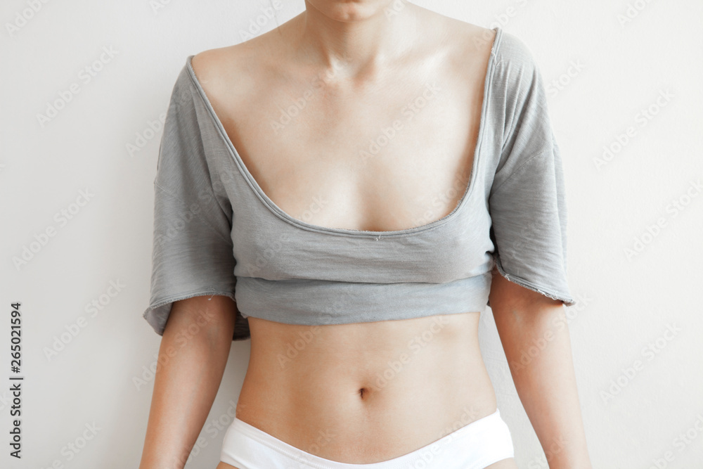 Fototapeta premium Closeup cropped portrait young woman with breast pain touching chest colored isolated on background