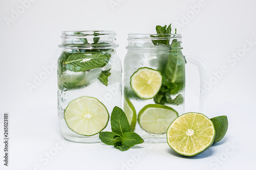 Healthy refreshing drink with ice, lime and mint isolated on white background.