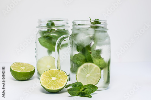 Healthy refreshing drink with ice, lime and mint isolated on white background.