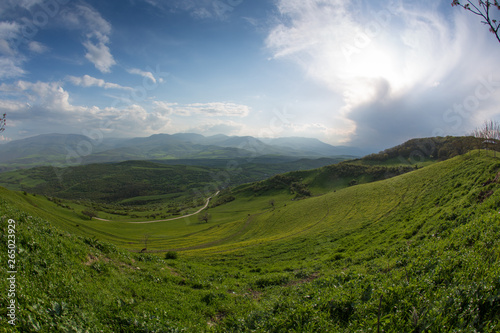Valley with green grass and mountains at background. Beautiful natural landscape in the summer time in Devichi, Azerbaijan.