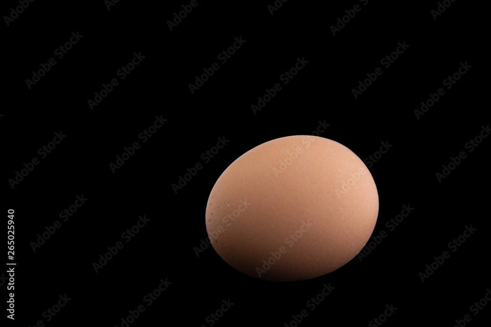 proper nutrition: chicken egg is isolated on a black background with shadows proper nutrition: chicken egg is isolated on a black background with shadows