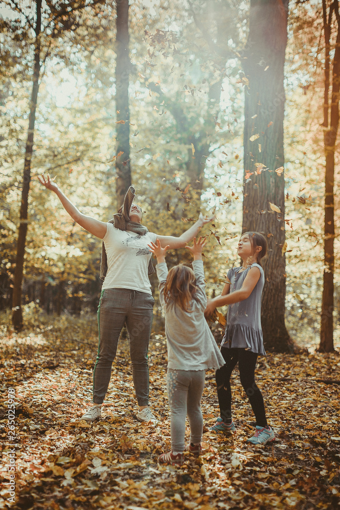 Rodzina bawi się w lesie jesień liście zabawa radość zdrowie szczęście - obrazy, fototapety, plakaty 