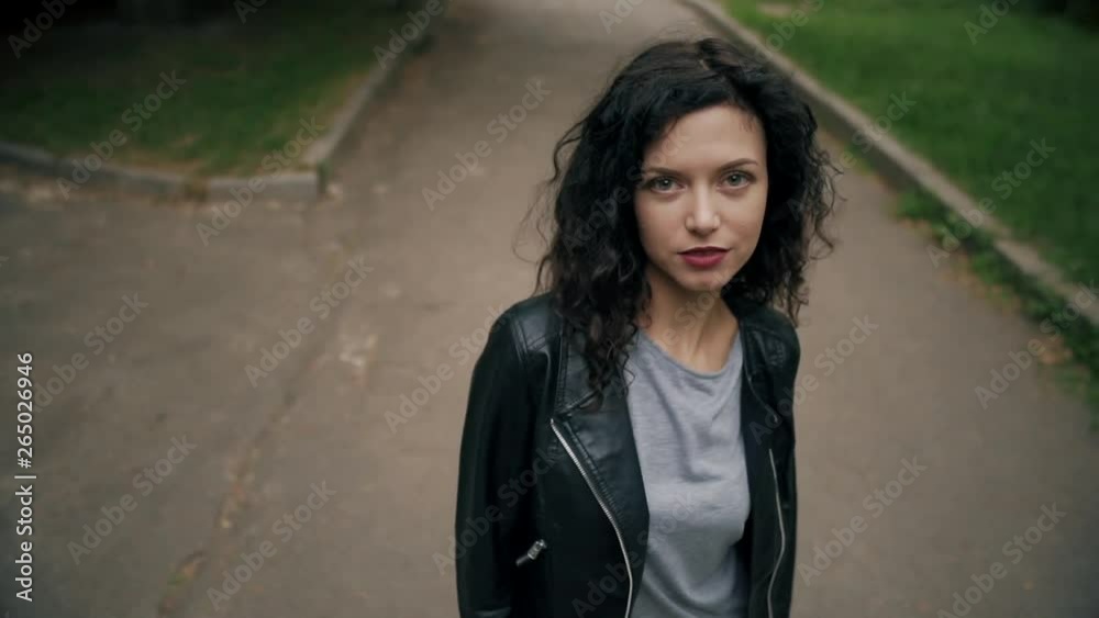 young beautiful curly brunette female smiling and walking young beautiful curly brunette female smiling and walking