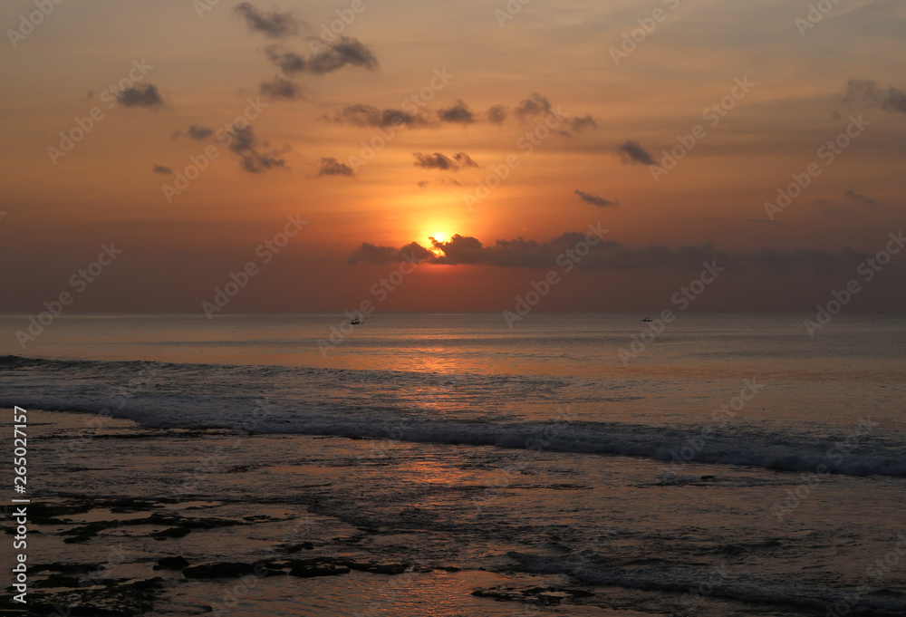 Bali beach sunset with fishing boats and bright sky